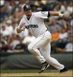 Seattle Mariners catcher Pat Borders watches from the dug out as