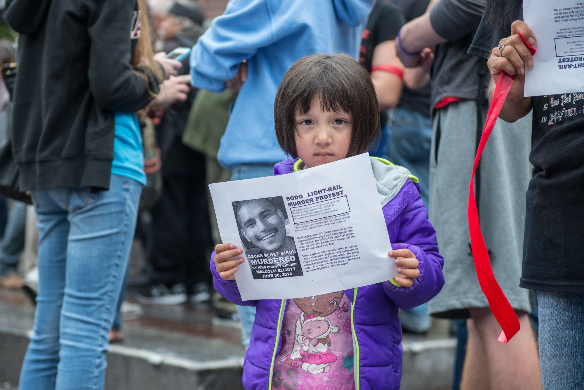 Young girl holding a flyer from a vigil  held in July for another gunshot victim. Photo by Morgen Schuler