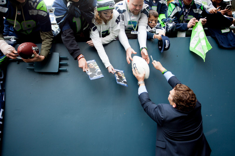 Seahawks' general manager John Schneider signs autographs before the game.